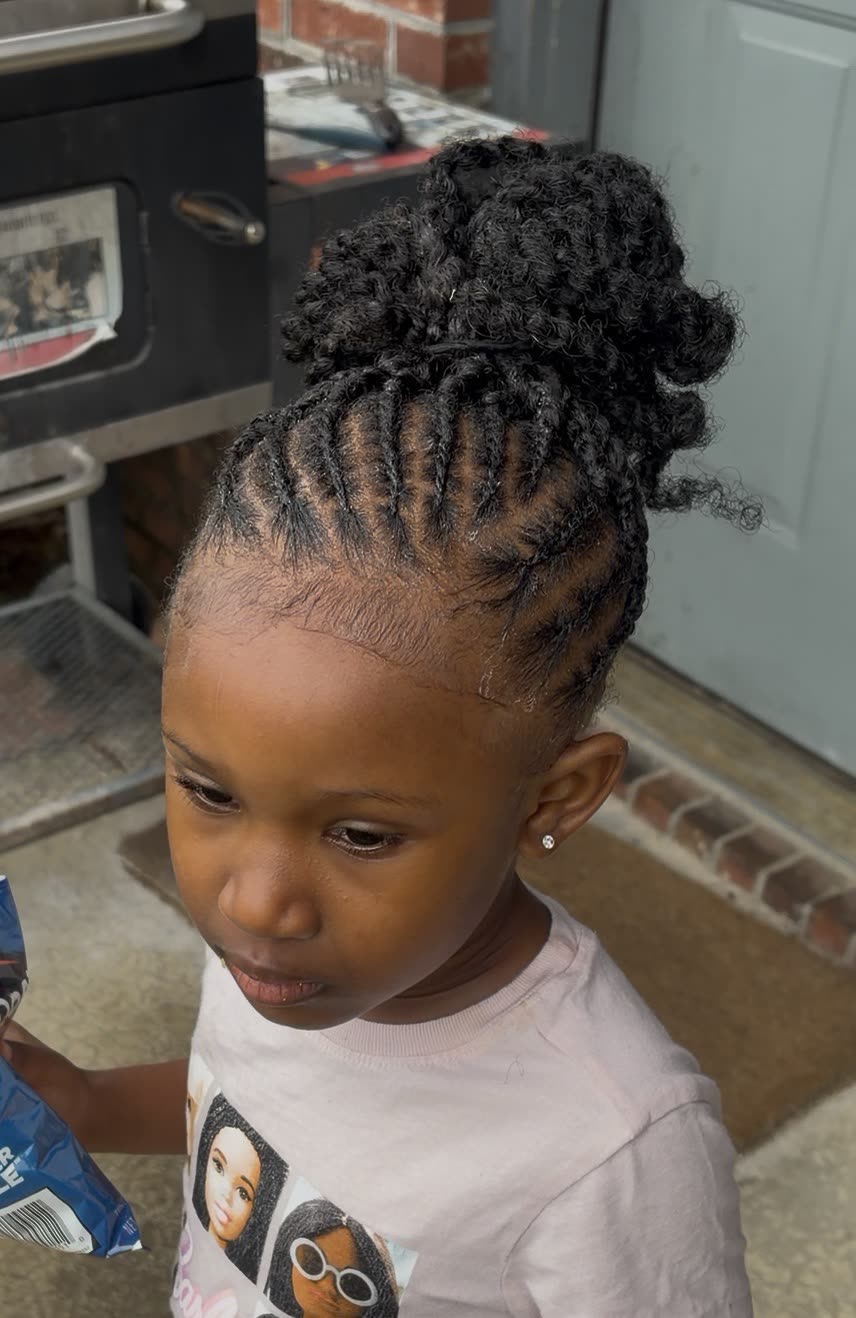 Scalp braids leading into a curly bun on a young client